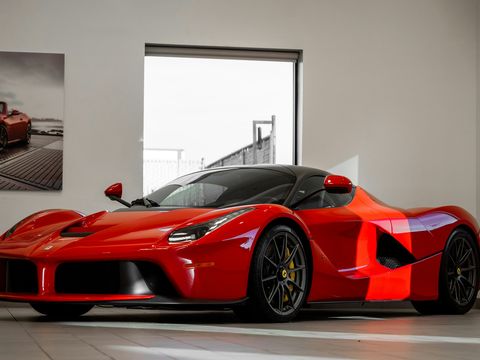 Roter Supersportwagen im Studio mit zugeschnittenen Folienbahnen